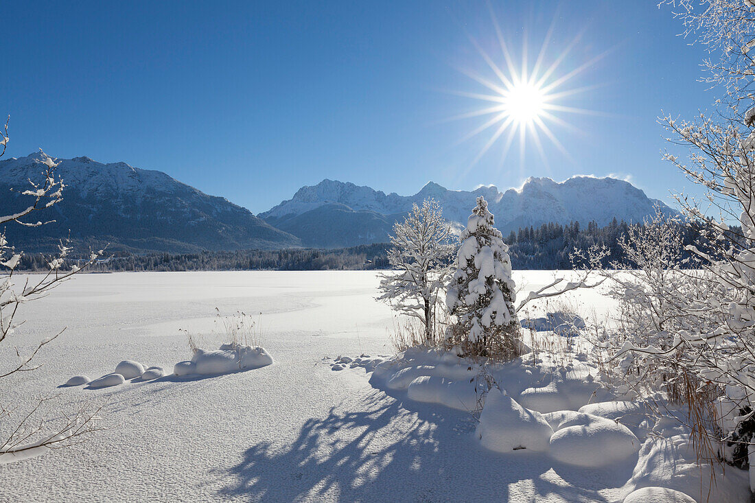 View over the ice at Barmsee to Soiern range and Karwendel range, Bavaria, Germany