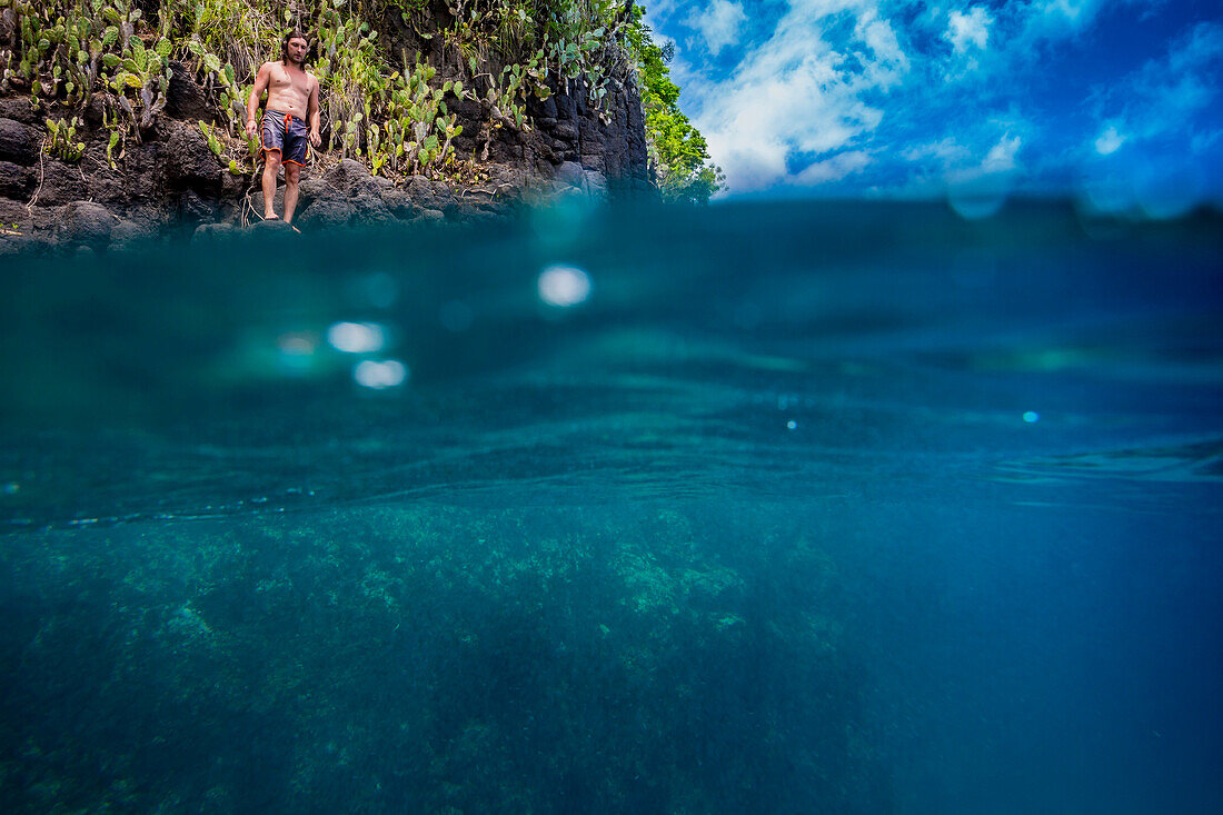 Man ready for jumping off cliff into the ocean. Summer fun lifestyle.