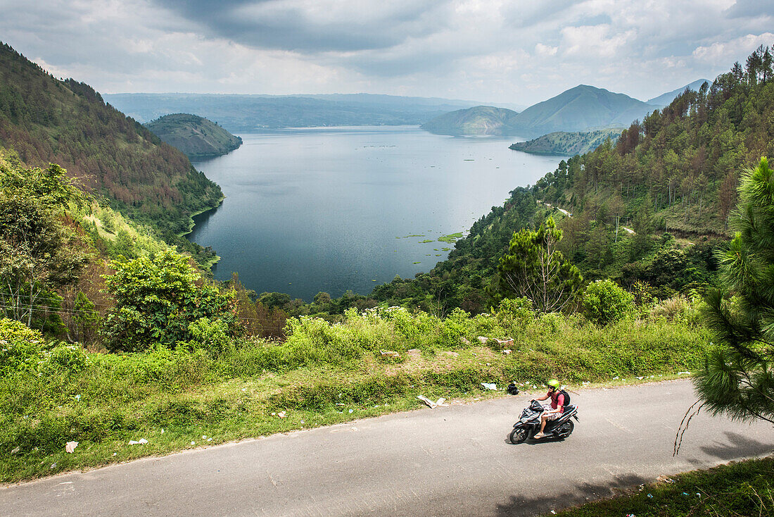 Tourist exploring Lake Toba (Danau Toba) by motorcycle, North Sumatra, Indonesia, Southeast Asia, Asia