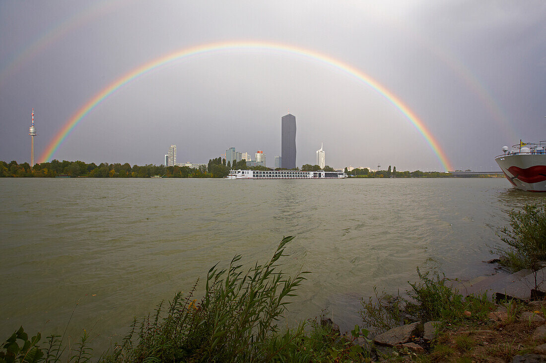 Rainbow and river cruiser A' ROSA BELLA and Donau City at Vienna on the river Danube , Austria , Europe