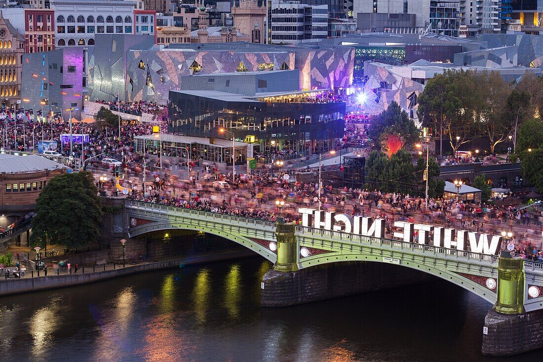 Australia, Victoria, VIC, Melbourne, White Nights Festival, buildings lit with projected laser designs, Federation Square and Princess Bridge, elevated view.
