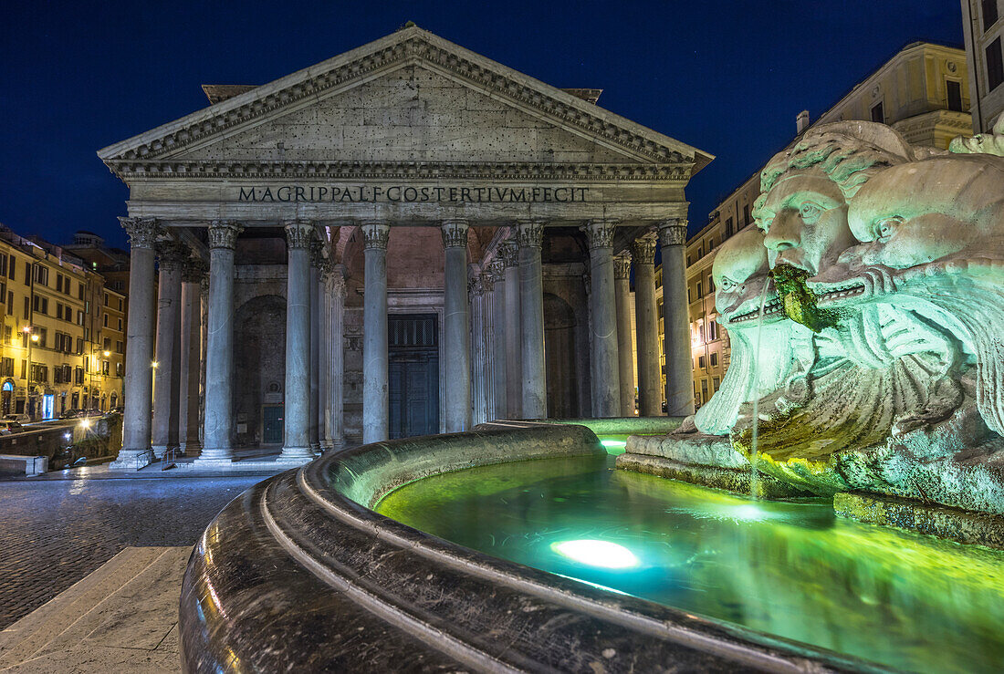 Rome, Lazio, Italy. The Fontana del Pantheon at night, on the background the Pantheon