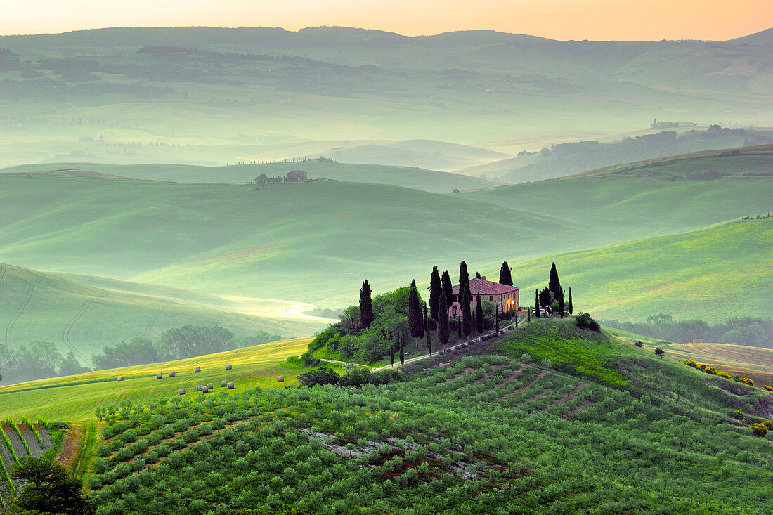Tuscany, Italy. A beautiful and lonely farmhouse surrounded by green hills of Val d'Orcia