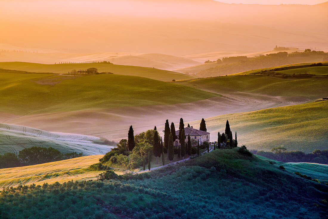 Val d'Orcia, Tuscany, Italy. A lonely farmhouse with cypress and olive trees, rolling hills.