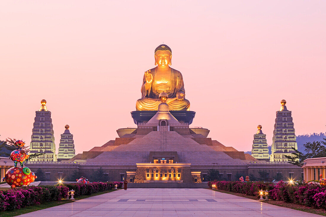 Kaohsiung, Taiwan. Sunset at Fo Guang Shan, the biggest buddist temple of Kaohsiung in Taiwan, with a buddhist monk walking by.