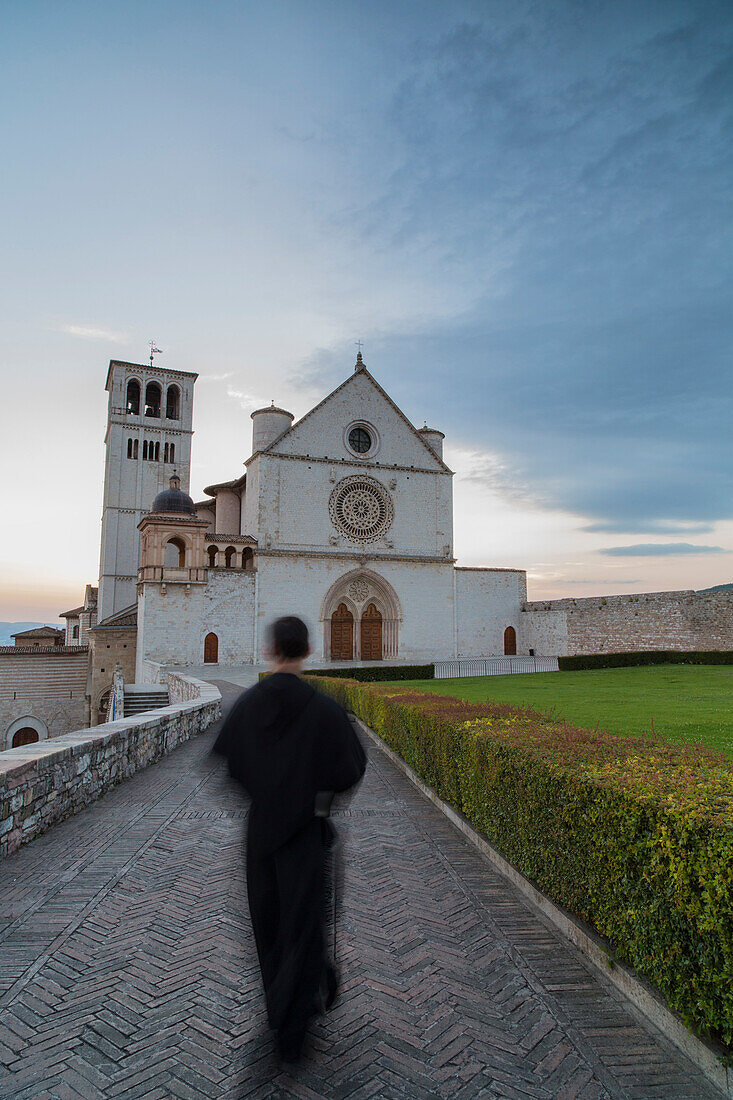 A monk walks toward the basilica of St. Francis in Assisi