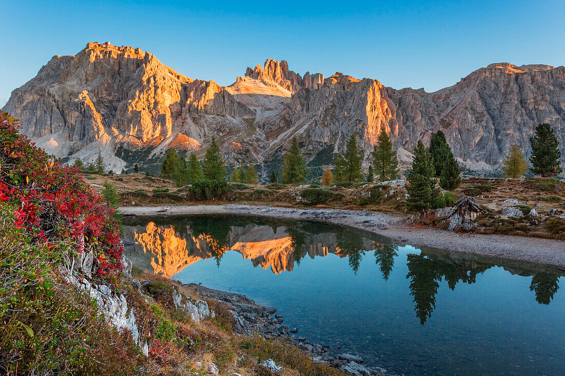 Europe, taly, Veneto, Belluno. Lake Limedes with the colors of autumn. In the background Lagazuoi and Fanis illuminated by the rays of the morning sun, Dolomites