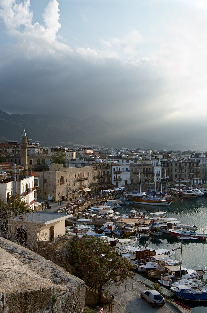 Blick von der Festung auf den Hafen von Girne,  dunkle Wolken über den Bergen, Kyrénia, Nord-Zypern