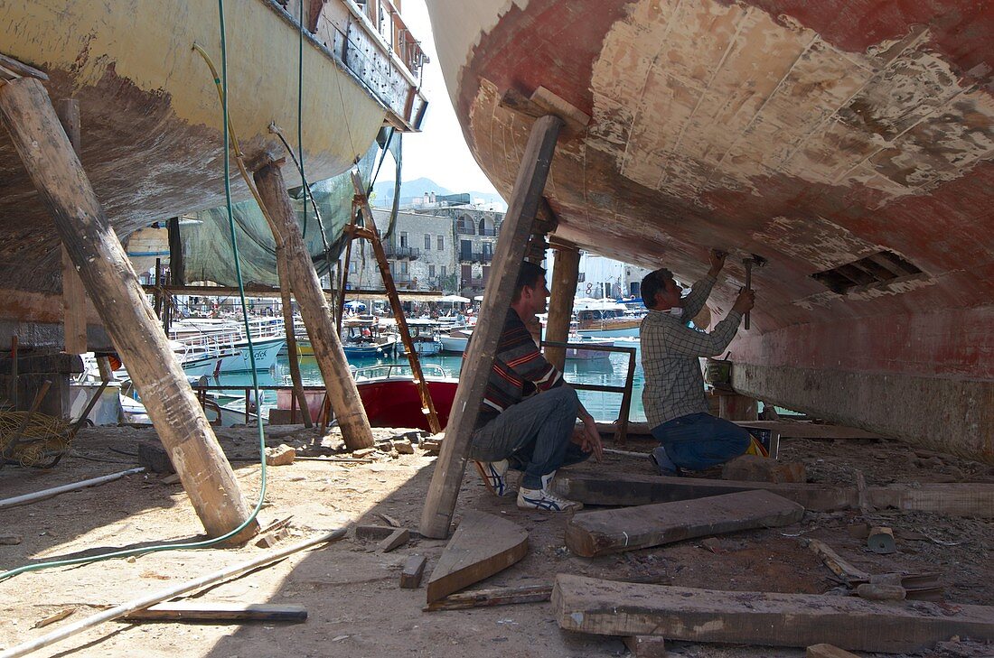 Men working on fishing boats in the drydock in the harbour in Girne,  North Cyprus