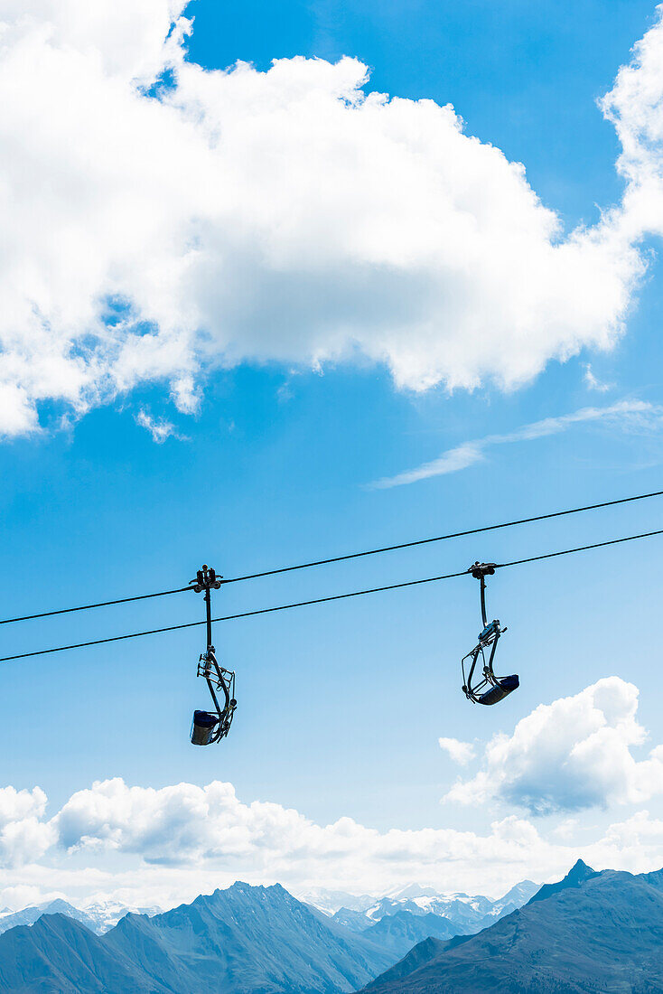 Ein Sessellift ohne Personen mit Gebirgskulisse, Kitzbüheler Alpen, Kitzbühel, Tirol, Österreich