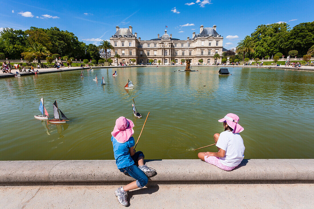 Girls play with sailing ships at the pond of the palace Palais du Luxembourg, Jardin du Luxembourg, 6.Arrondissement, Quartier Latin, Paris, France