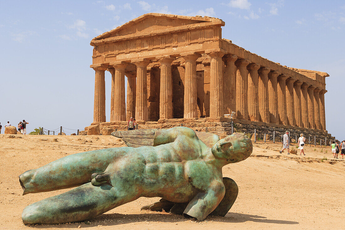The Statue of Ikaro Caduto by Igor Mitoray and The Temple of Concordia or Harmonia, Akragas,The Valle dei Templi, Valley of the Temples, Vaddi di li Tempri, Agrigento, Sicily, Southern Italy.