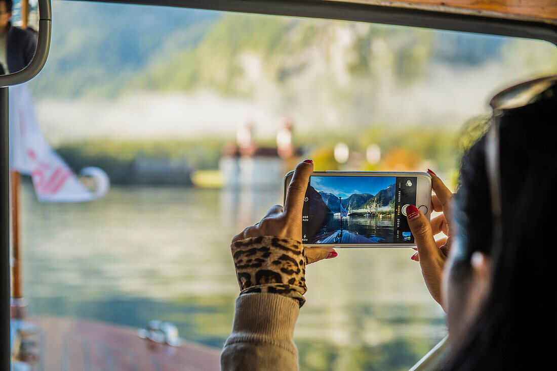 woman with smartphone, St Bartholomew's, Königssee, Berchtesgaden National Park, Berchtesgadener Land, Upper Bavaria, Bavaria, Germany