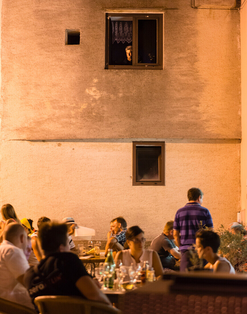 Dorfplatz mit Restaurants und Gästen am Abend im Dorf Vrbnik - Kroatien, Insel Krk