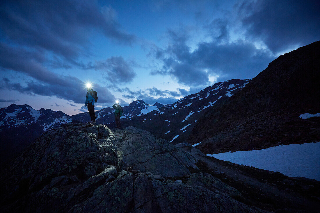 Bergsteiger im Dunkel mit Stirnlampe auf dem Berg