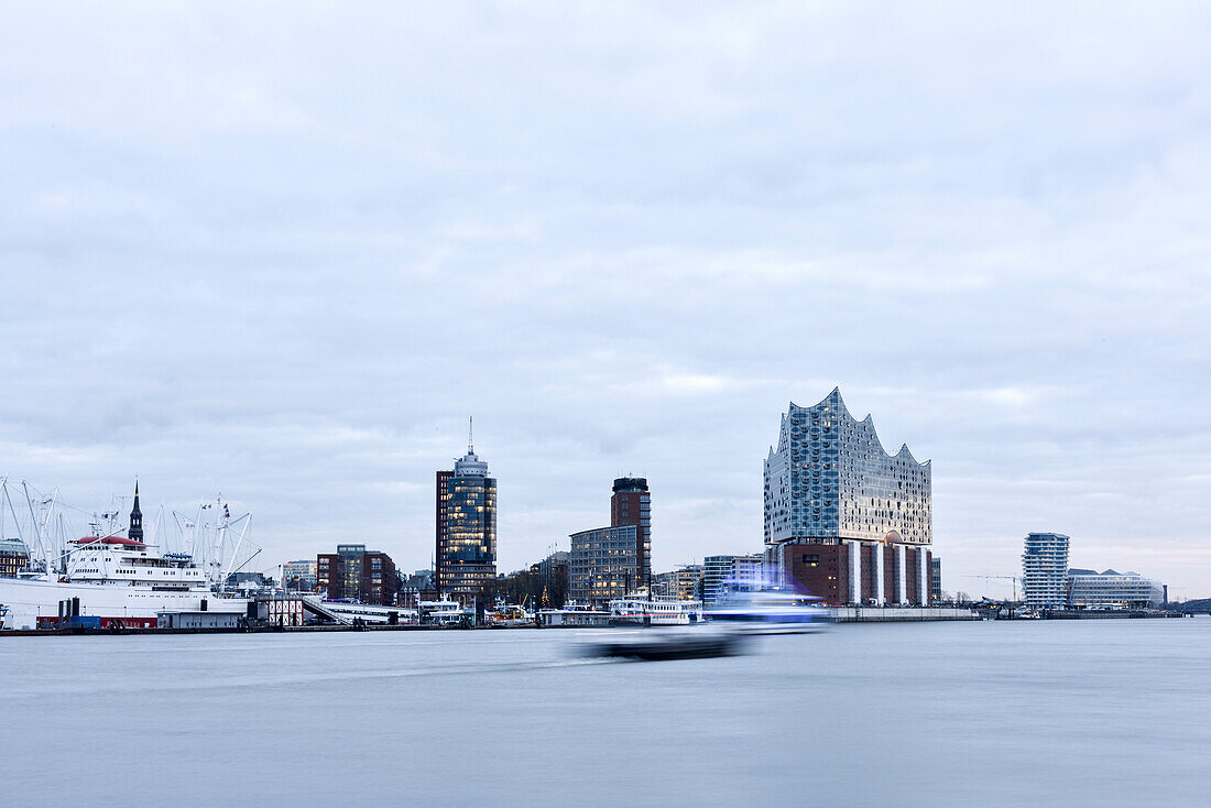 Hamburg Skyline Panorma mit Elbphilharmonie in der Dämmerung mit Elbe im Vordergrund, Hamburg, Deutschland