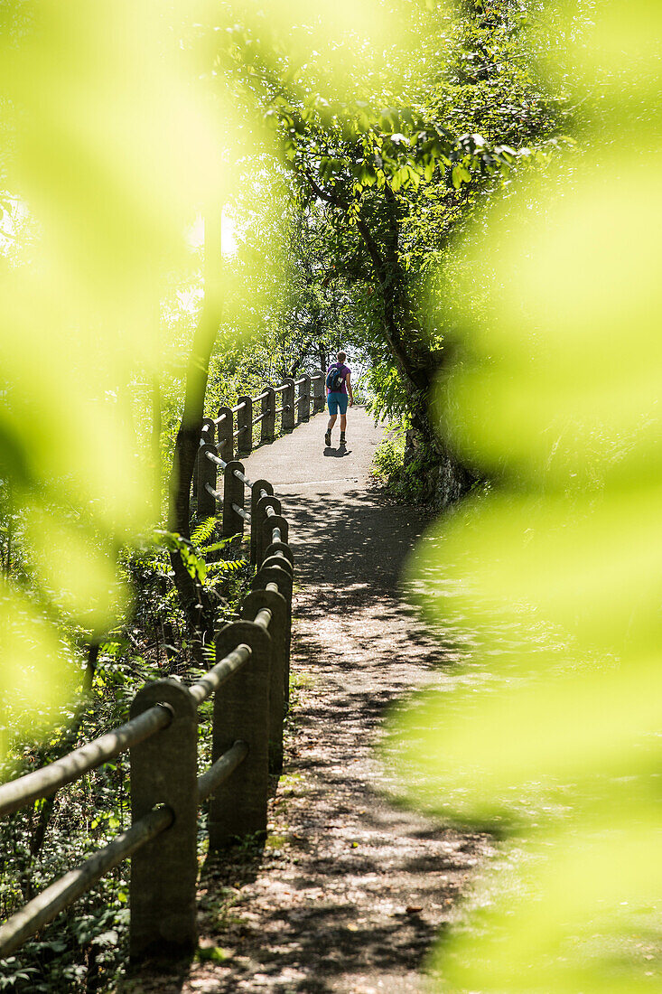 Young female hiker walking on a path, Valle Verzasca, Ticino, Switzerland