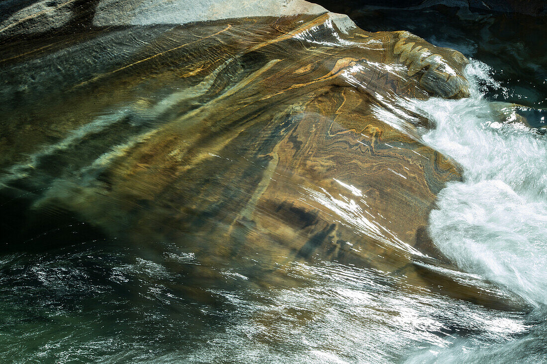 Wasser fließt über einen Felsen in einem Fluss, Val Verzasca, Tessin, Schweiz