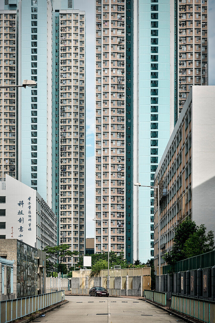 Schulgebäude vor riesigen Hochhäusern in Satelittenstadt Tin Shu Wai, Hongkong, China, Asien