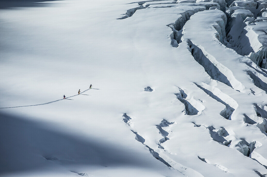 Drei junge Wintersportler machen eine Skitour durch den Tiefschnee, Pitztal, Tirol, Österreich