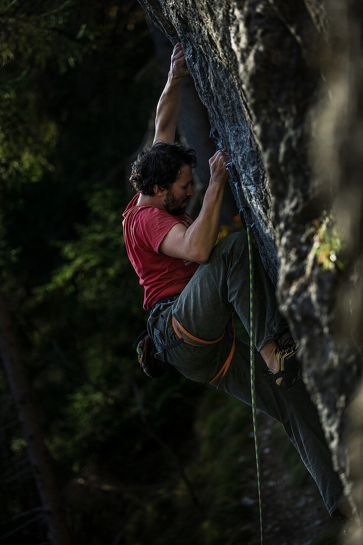 Young man climbing at a rock face, Schwaerzer Wand, Bavaria, Germany