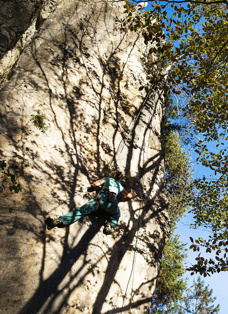 Young woman climbing at a rock face, Schwaerzer Wand, Bavaria, Germany