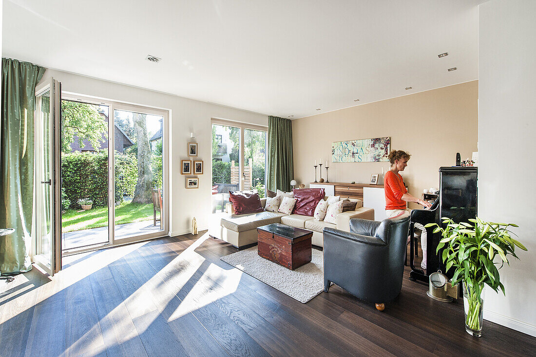 women at the piano in a living room of a modern sigle-family house in Hamburg, north Germany, Germany