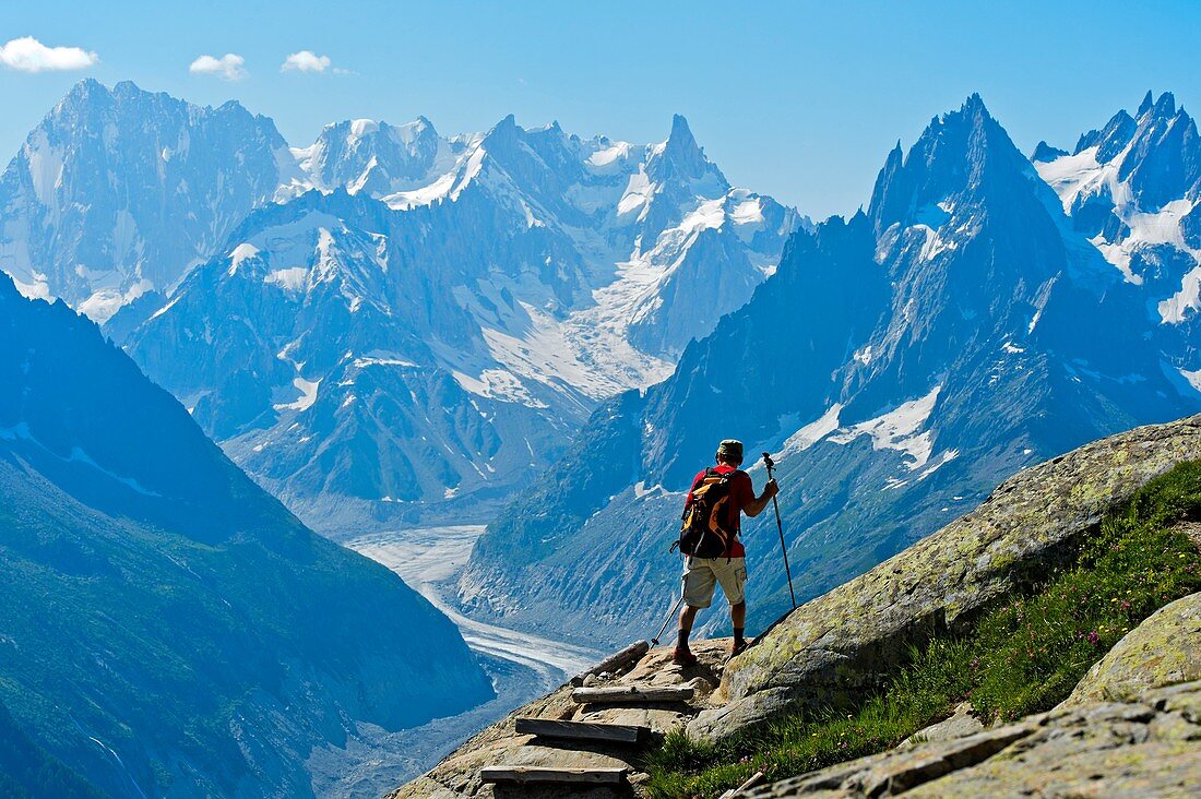 Hiker in the Aiguilles Rouges National Nature Reserve, view at the peaks Grandes Jorasses und Dent du Géant, Chamonix, Haute-Savoie department, France.