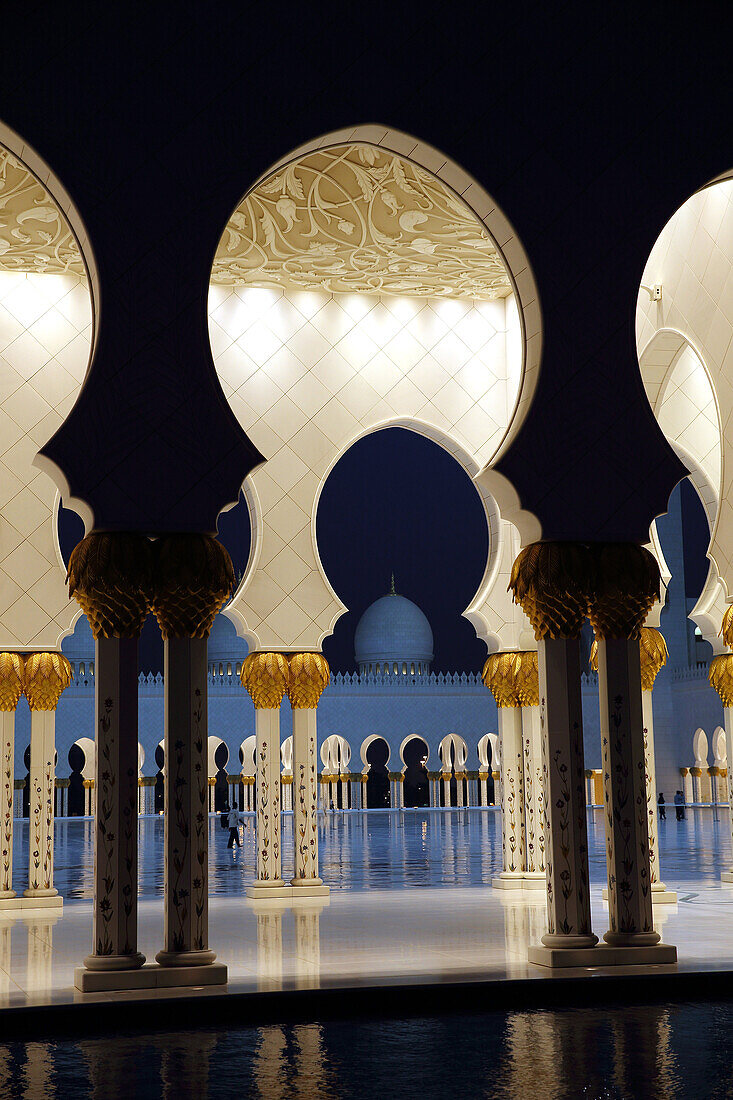 People walking in the courtyard and arcades of Sheik Zayed Grand Mosque, Abu Dhabi, United Arab Emirates, Asia.