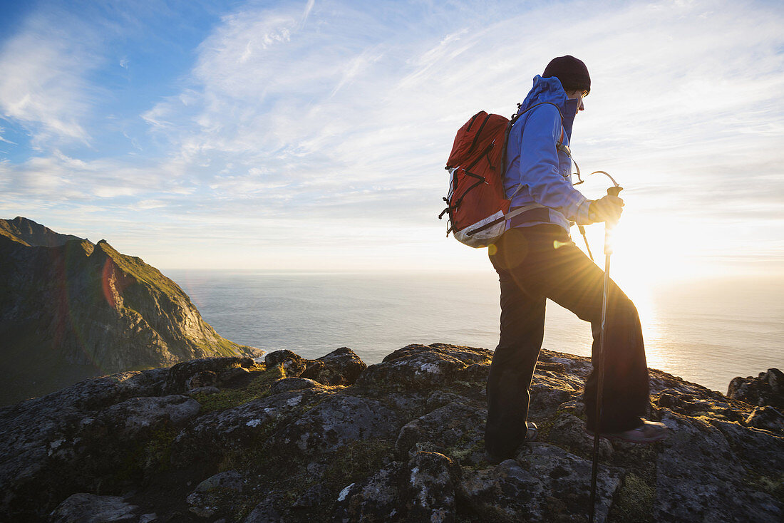 Female hiker hiking in Evening summer sun on summit of Ryten, Moskenesoy, Lofoten Islands, Norway.