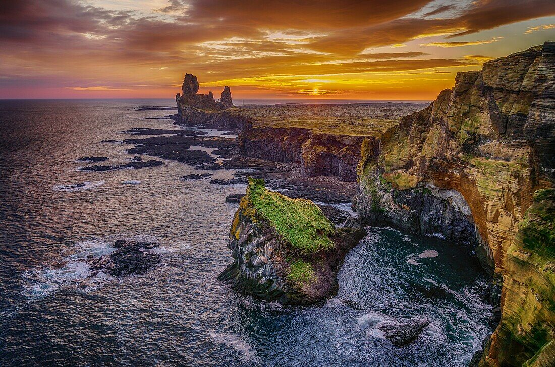 Londrangar sea stacks and the Thufubjarg cliffs. Londrangar are basalt volcanic dikes that were formed after magma solidified and after years of erosion these sea stacks remain, Snaefellnes Peninsula, Iceland.