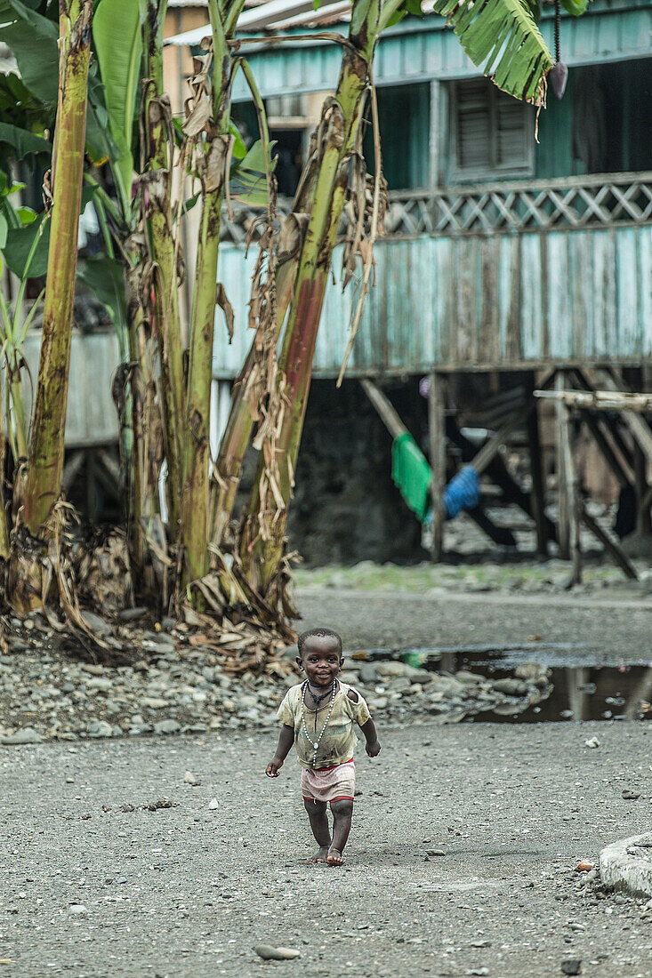 Kleines Kind in einfacher Kleidung läuft durch eine arme Gegend, Sao Tome, Sao Tome und Príncipe, Afrika