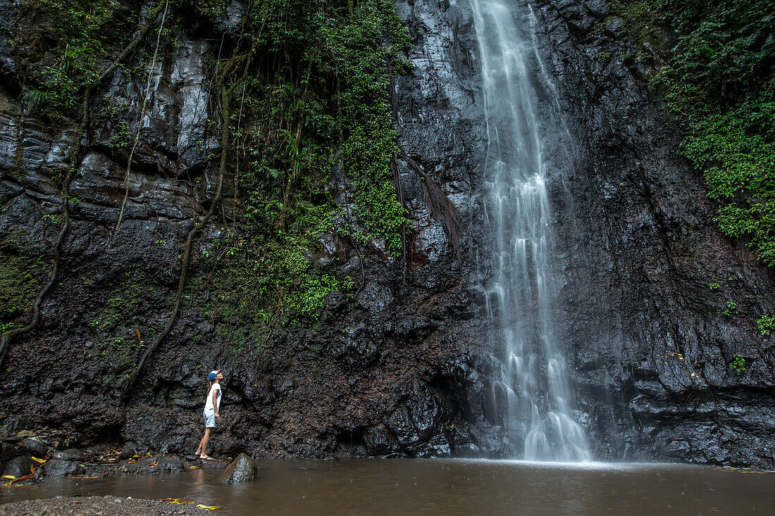 Junge Frau steht an einem Wasserfall, Sao Tome, Sao Tome und Príncipe, Afrika