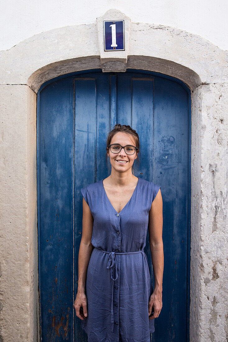 Junge Frau steht vor einer blauen Tür, Sao Tome, Sao Tome und Príncipe, Afrika