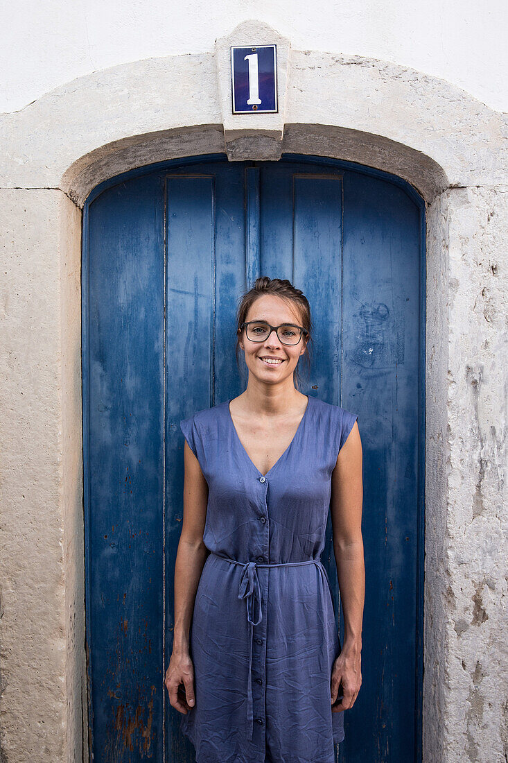 Young woman standing in front of a blue door, Sao Tome, Sao Tome and Principe, Africa