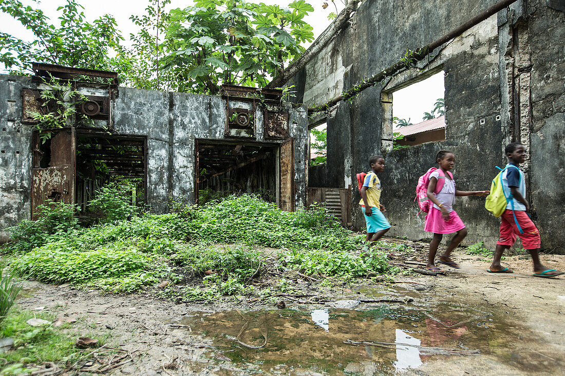 Drei kleine eingeborene Mädchen gehen durch eine Ruine, Sao Tome, Sao Tome und Príncipe, Afrika