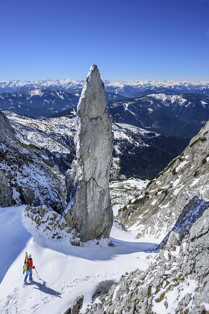 Frau auf Skitour steht in Angersteinscharte, Blick auf Felsturm Angersteinmandl, Angerstein, Gosaukamm, Dachstein, Salzburg, Österreich