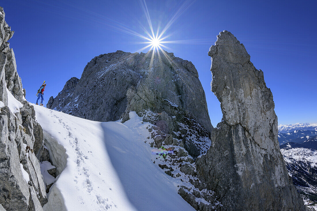 Woman back-country skiing standing in Angersteinscharte, view to Angerstein and spire of Angersteinmandl, Angerstein, Gosau range, Dachstein, Salzburg, Austria