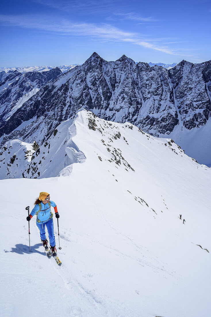 Woman back-country skiing ascending to Hoher Seeblaskogel, Luesenser Fernerkogel in background, Hoher Seeblaskogel, Sellrain, Stubai Alps, Tyrol, Austria