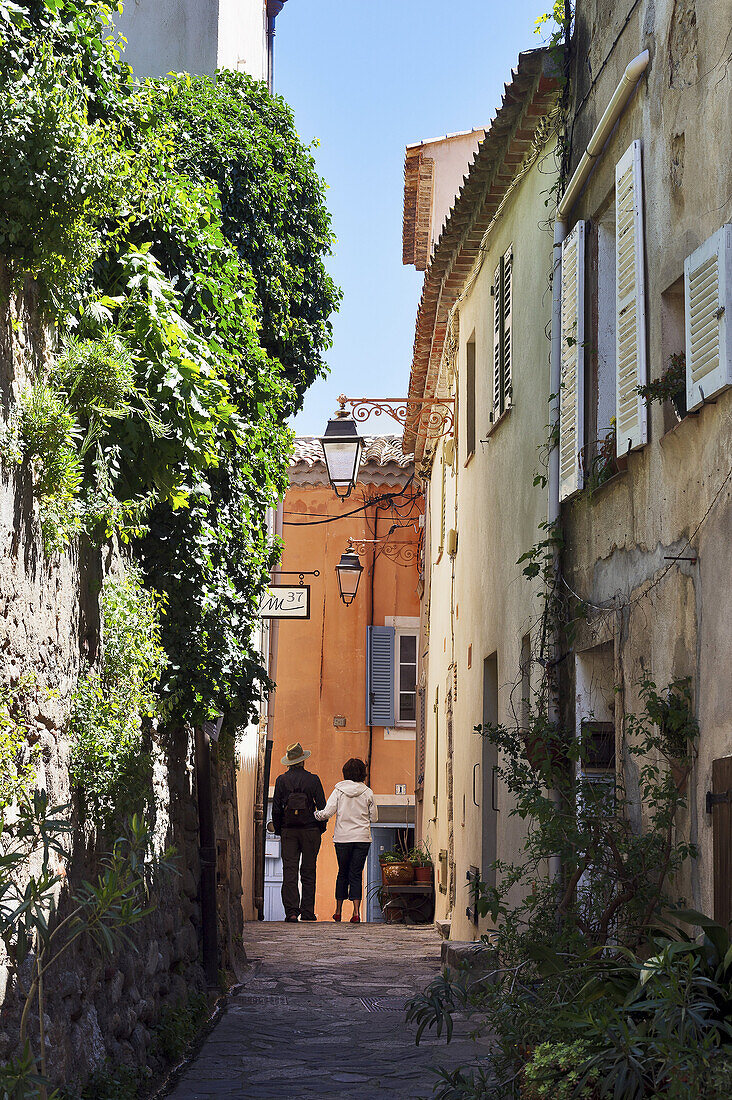 Europe, France, Var. Ramatuelle. Couple walking in a typical alley in the village.