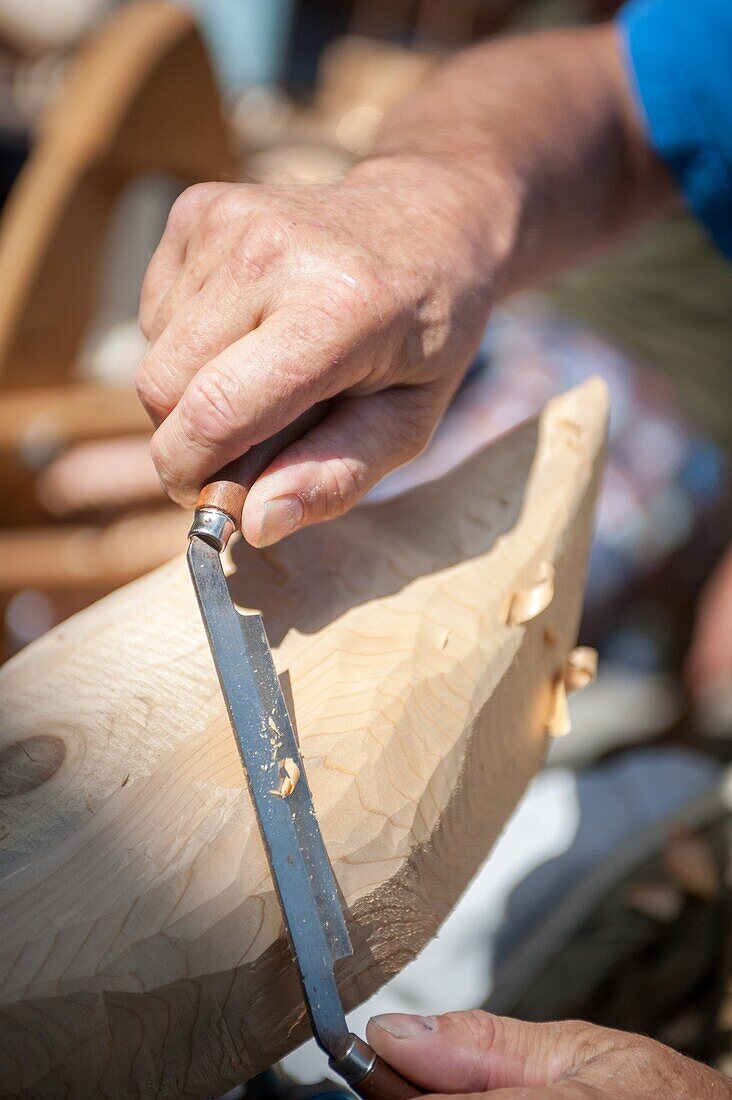 Hands using a spoke plane to carve a wooden duck decoy in Baltimore, Maryland, USA.