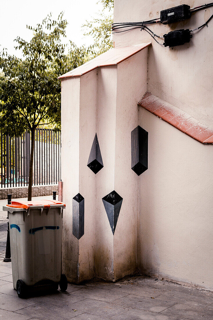 Dustbin and graffiti on a corner in the neighborhood of Lavapies, Madrid, Spain