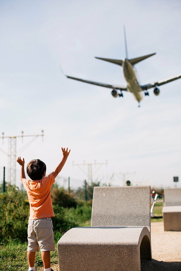 boy watching a plane landing at the Barcelona airport.