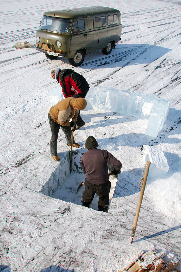Man sawing an ice-hole for ice-diving, in Lake Baikal, Olkhon island, Siberia, Russia, Eurasia.