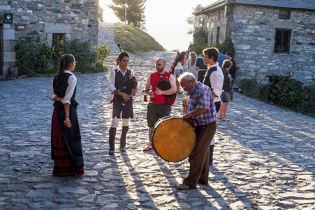 Sunset in the village of Cebreiro while a group plays the bagpipes.