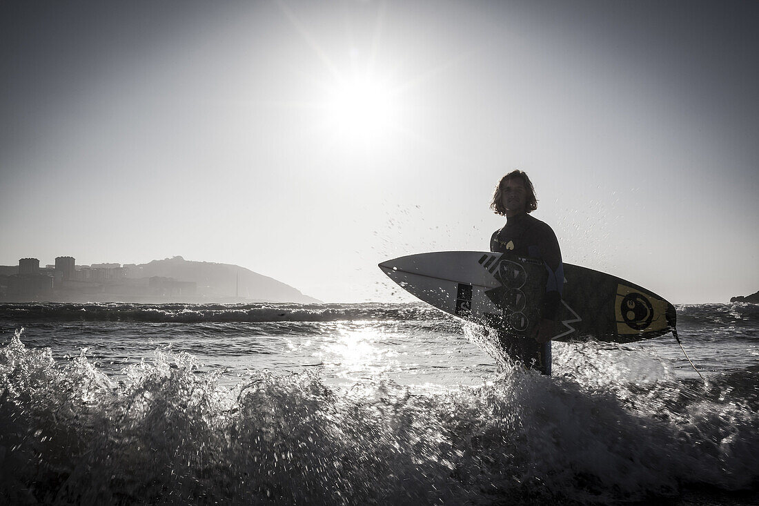 Surfer Pablo Macineira holding surfboard. Orzan Beach. A Coruña. Galicia. Spain.