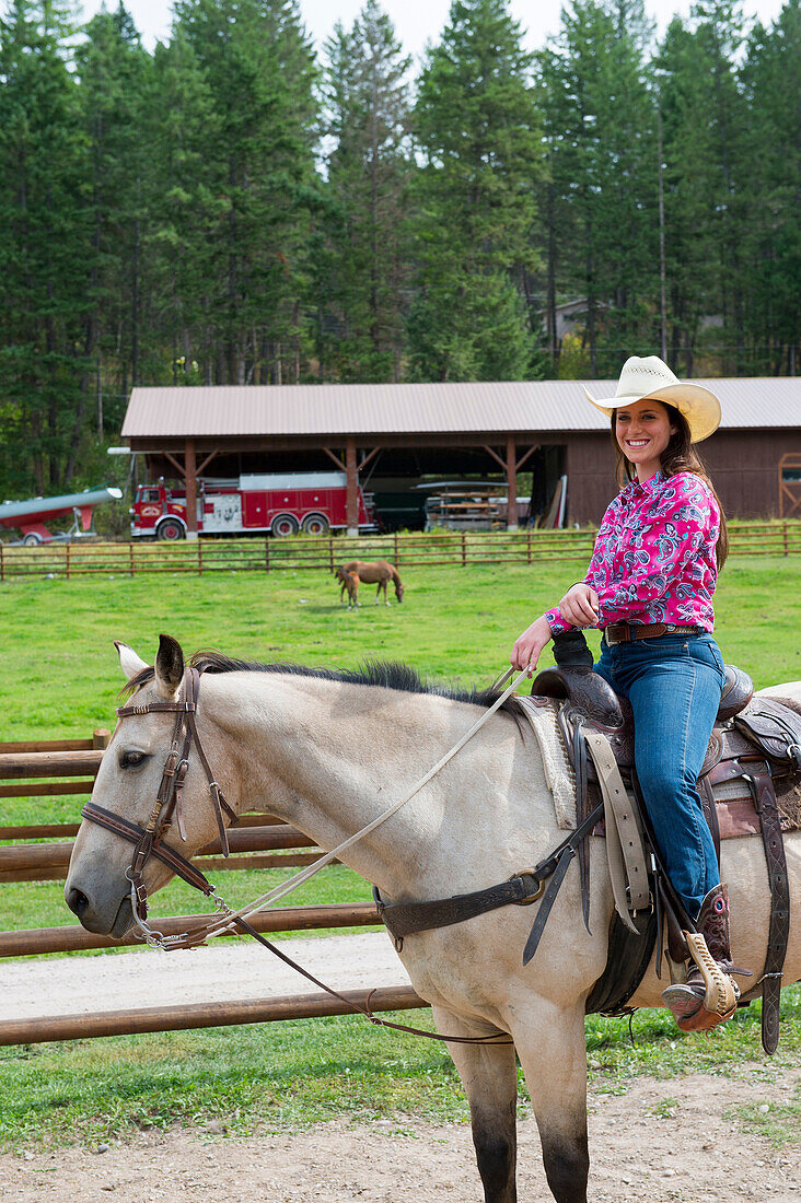 Cowgirl (Wrangler) on horse at Averill´s Flathead Lake Lodge, a dude ranch near Kalispell, Montana, United States.
