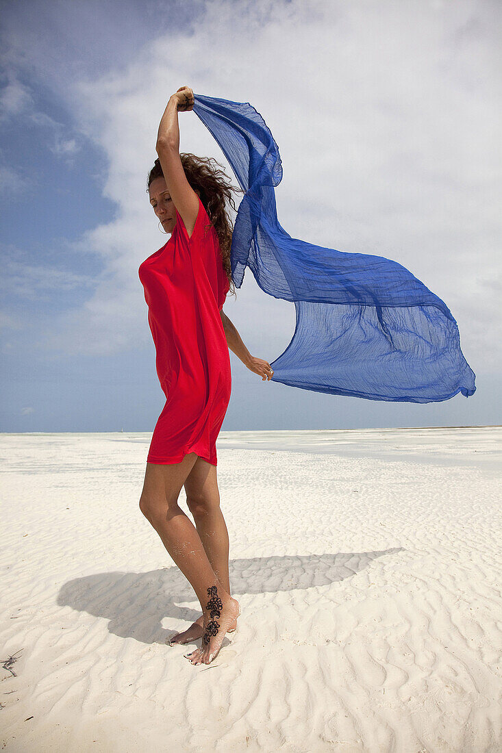 Woman with red dress on the beach, Jambiani, Zanzibar, Tanzania, East Africa.