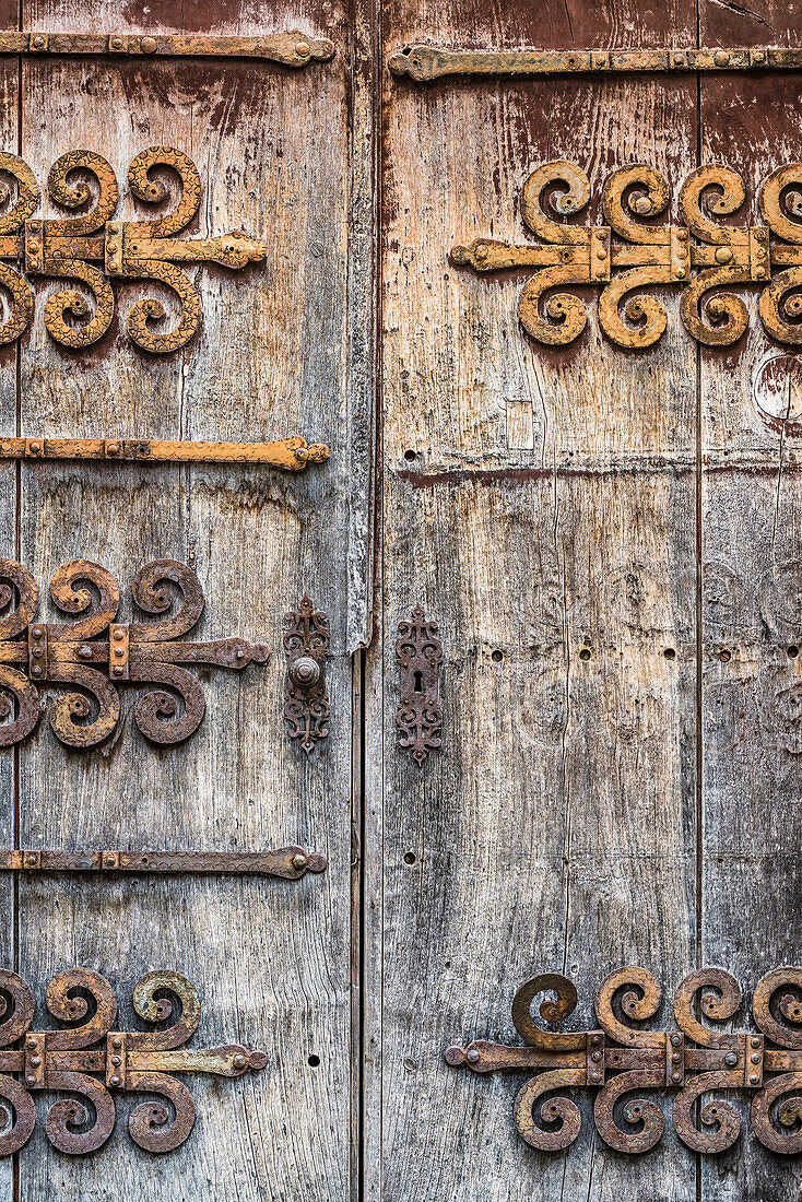 Eine alte verwitterte Holztür mit Metallbeschlägen, Ronda, Andalusien, Spanien