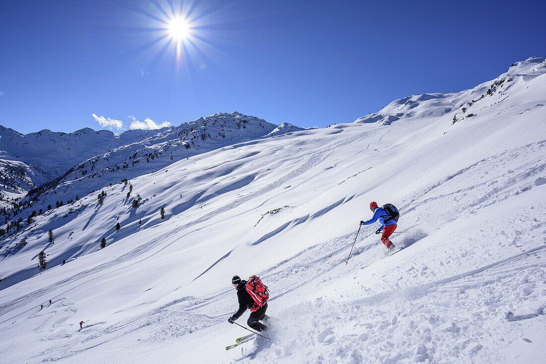 Zwei Personen auf Skitour fahren durch Pulverschnee vom Sonnenjoch ab, Sonnenjoch, Kitzbüheler Alpen, Tirol, Österreich